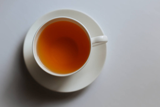 taza de té sobre fondo blanco. taza blanca con un té aislado en un fondo blanco. vista superior. - Foto, Imagen