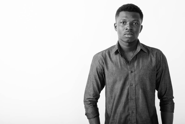 Estudio de un joven empresario africano sobre fondo blanco en blanco y negro - Foto, Imagen