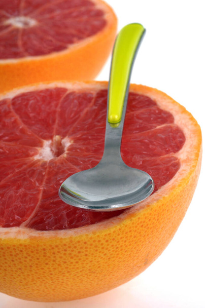 Rózsaszín grapefruit egy kanállal közelkép fehér háttér - Fotó, kép