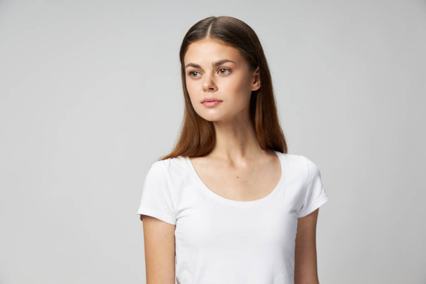 vrouw in wit bijgesneden t-shirt levensstijl kijkt naar de zijkant  - Foto, afbeelding