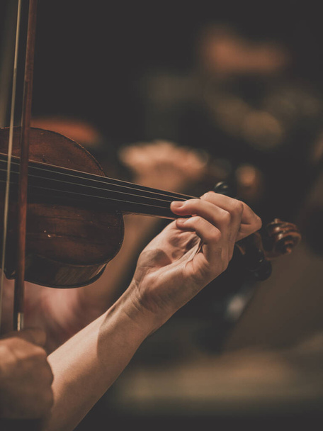Szoros keret egy szimfonikus zenekar hegedűsének kezéhez - Fotó, kép