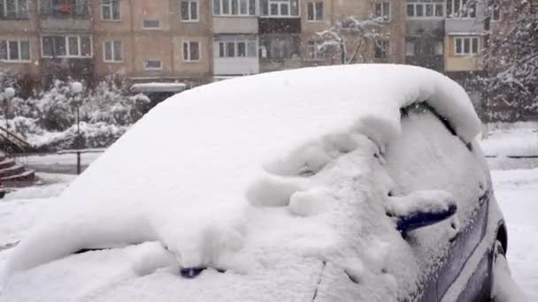 Sininen auto, paksun lumikerroksen peitossa. Ulkona sataa lunta.. - Materiaali, video