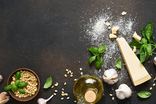 Ingredients for the pesto sauce: Parmesan, basil and pine nuts on a concrete background. Pesto sauce top view. - Fotoğraf, Görsel