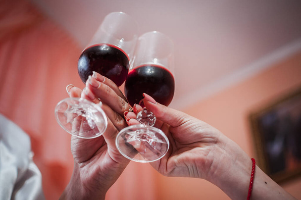 szklanki z czerwonym winem w rękach dziewcząt - Zdjęcie, obraz