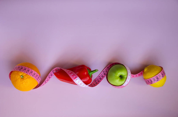 Творческая плоская композиция с яблоком, перцем, лемоном, апельсином на розовом фоне. Периодические, кето, детоксикация и тонкие диеты. Концепция здорового питания. Копирование пространства. - Фото, изображение