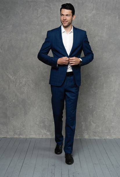 full length of handsome man wear blue suit isolated on grey background. - Foto, Imagen