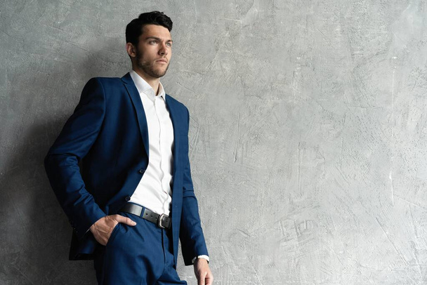 Handsome man wear blue suit isolated on grey background. - Foto, imagen