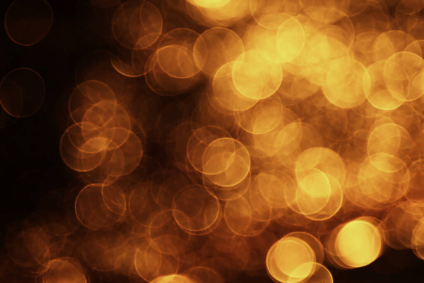 blurred bokeh blurs of orange light on dark grungy background - Foto, afbeelding
