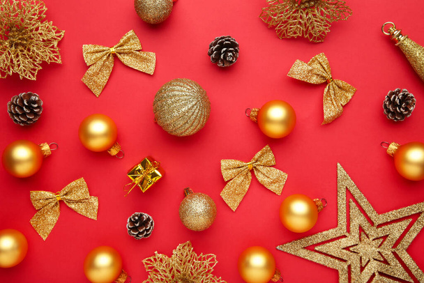 Christmas composition made of christmas gold decoration on red background. Flat lay, top view. - Photo, Image