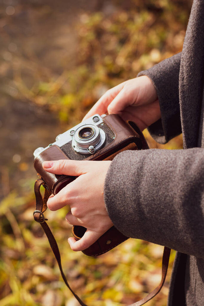 Rare camera in hands in autumn park - Zdjęcie, obraz