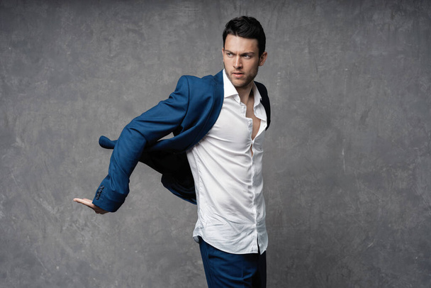 Handsome man wear blue suit isolated on grey background. - 写真・画像