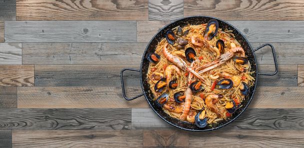 Deniz mahsullü makarna paella, ahşap arka planda İspanyol mutfağı, kopyalama alanı. - Fotoğraf, Görsel