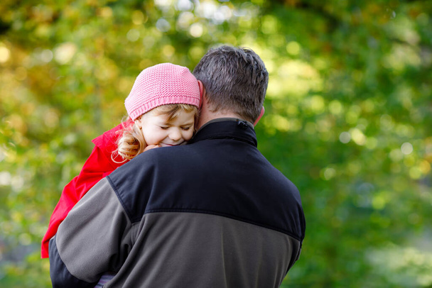 Happy young father having fun cute toddler daughter, family portrait together. Middle-aged Man with beautiful baby girl in autumn forest or park. Dad with little child outdoors, hugging. Love, bonding - Photo, Image