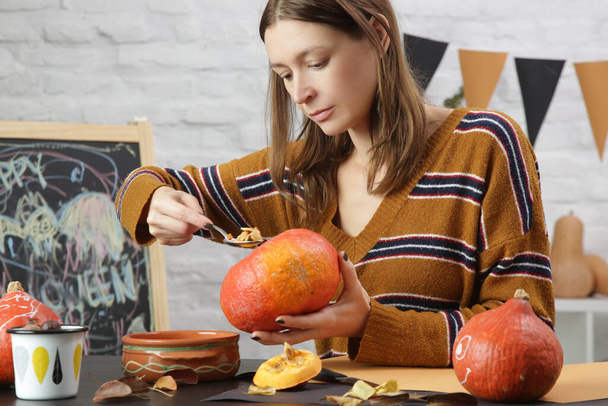 Young woman making Halloween decorations at home. Autumn season DIY craft. - Foto, afbeelding