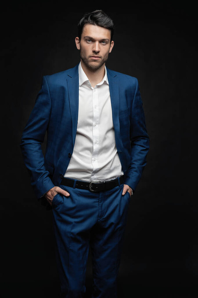Handsome man wear blue suit isolated on black background. - 写真・画像