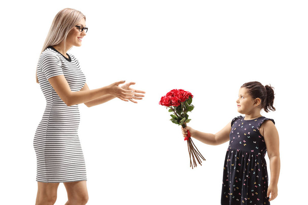 Girl giving red roses to a young woman isolated on white background - 写真・画像