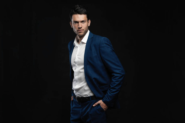 Handsome man wear blue suit isolated on black background. - Photo, image
