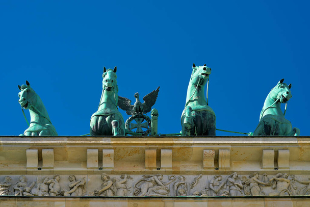 Quadriga przy Bramie Brandenburskiej w Berlinie z bezchmurnym niebem widzianym od dołu                                - Zdjęcie, obraz