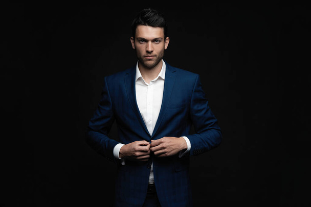 Handsome man wear blue suit isolated on black background. - Фото, изображение