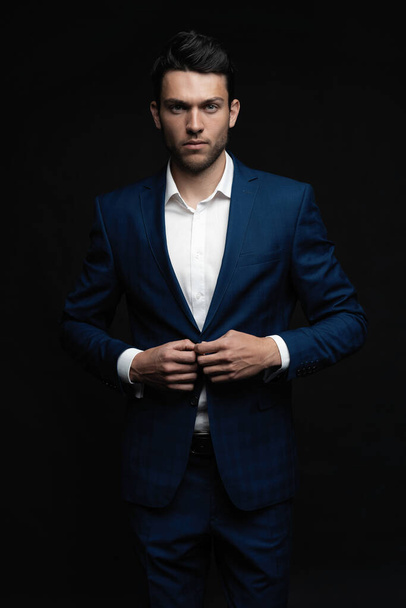 Handsome man wear blue suit isolated on black background. - Foto, afbeelding