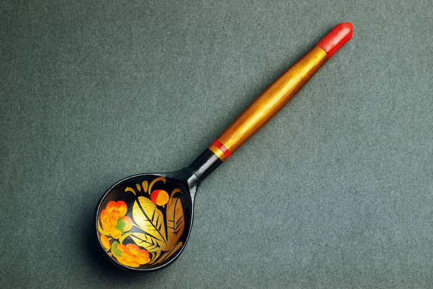 Russian national artistic wooden spoon on black paper texture  - Valokuva, kuva