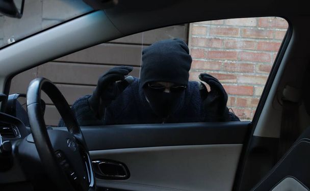Hırsız araba camından içeri bakıyor. - Fotoğraf, Görsel