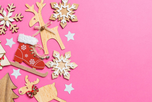 Top view of pink background decorated with festive toys and Christmas symbols reindeers and New Year trees. Holiday concept with copy space. - Φωτογραφία, εικόνα