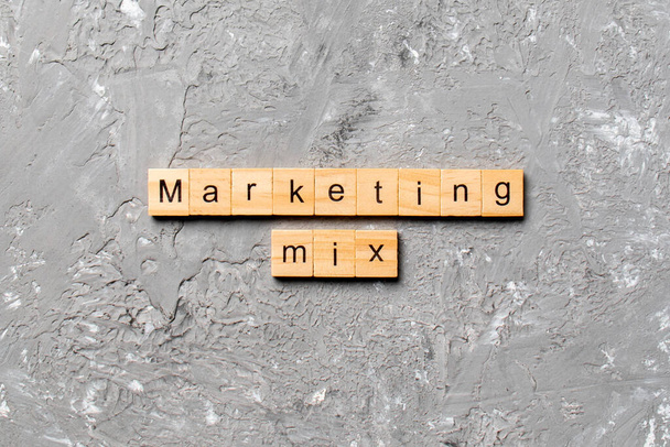 マーケティングMIX木のブロックに書かれた単語。あなたの設計、概念のためのセメントテーブル上のマーケティングミックステキスト. - 写真・画像