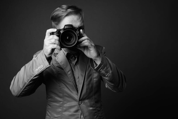 Studio shot de blond barbu homme d'affaires avec bouc sur fond gris en noir et blanc - Photo, image