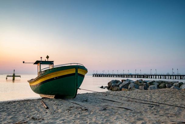 ανατολή και αλιευτικό σκάφος στην παραλία στην Gdynia - Φωτογραφία, εικόνα