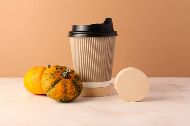 Craft cup of coffee with mini pumpkins and round figure near it.Spicy latte concept.Autumn beverages,cozy atmosphere. - Photo, Image