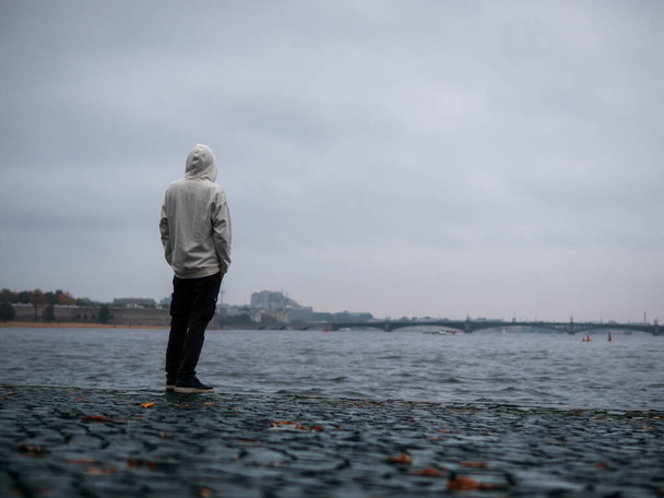 Silhouette d'un homme à capuche blanche sur fond de Saint-Pétersbourg. Météo pluvieuse - Photo, image