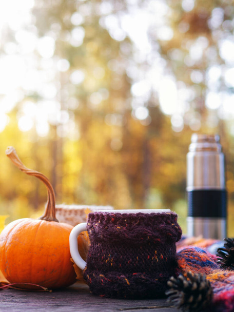 秋の森の中の木のテーブルの上に熱いコーヒーやお茶のカップ。10月の暖かい日をお楽しみください。 - 写真・画像
