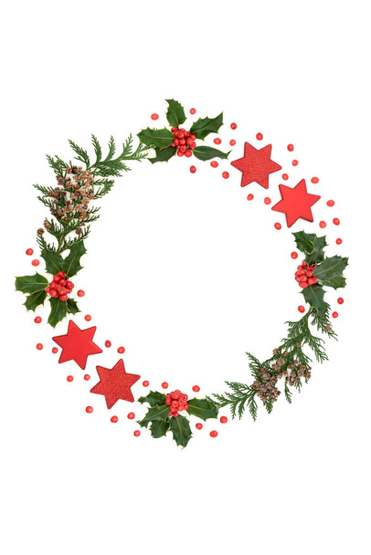 Abstract Christmas wreath with holly, cedar cypress, red star decorations with loose berries on white background. Traditional theme for the festive holiday season, Flat lay, top view, copy space. - Photo, Image
