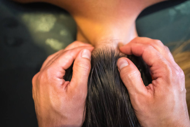 A young woman receiving a head massage by a physical therapist. Physio, osteopathy - Fotoğraf, Görsel