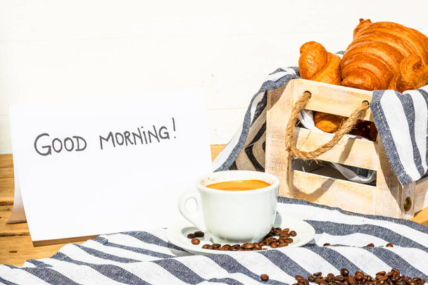 Kaffeetasse und gebuttertes frisches französisches Croissant auf Holzkiste - Foto, Bild