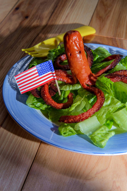 Fancy hot dog cut to the shape of an octopus holding an American flag - Photo, Image
