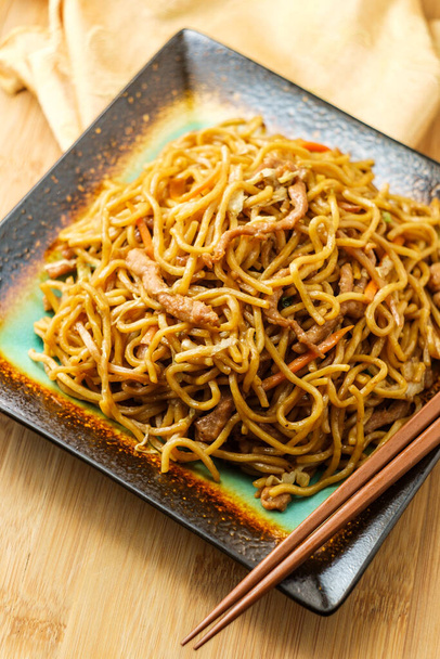 Jedzenie chińskiej wieprzowiny lo mein makaron z pałeczkami - Zdjęcie, obraz