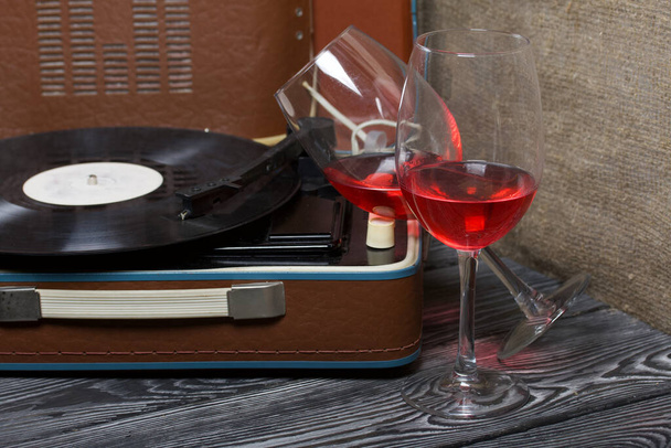 Old turntable. Nearby are two glasses of alcohol. Retro party equipment. - Zdjęcie, obraz