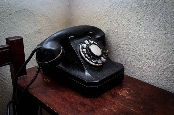 木製机の上に古いヴィンテージロータリーダイヤル電話 - 写真・画像