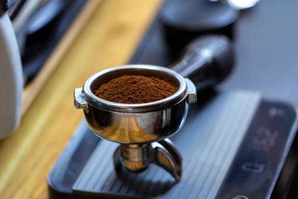 Portafilter with freshly ground morning coffee on the scales - Photo, Image