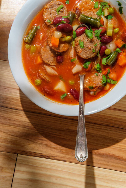 Сердечный итальянский минестронский суп с нарезанной колбасой и овощами - Фото, изображение