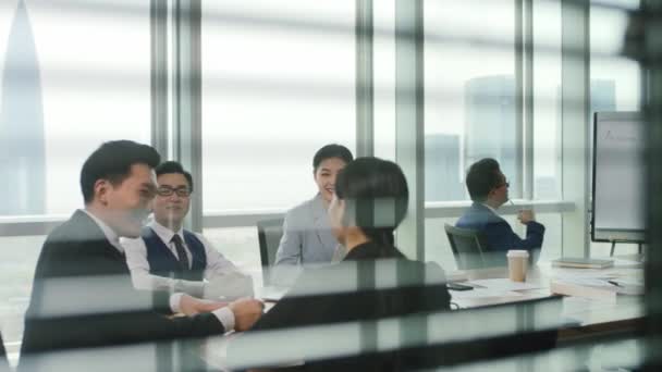 группа азиатских бизнесменов обсуждает бизнес-план в современном офисе - Кадры, видео