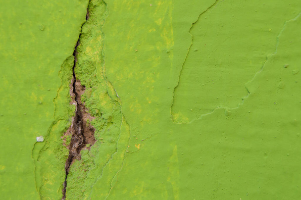 пилинг зеленого цвета стены с трещиной и паутины внутри - Фото, изображение