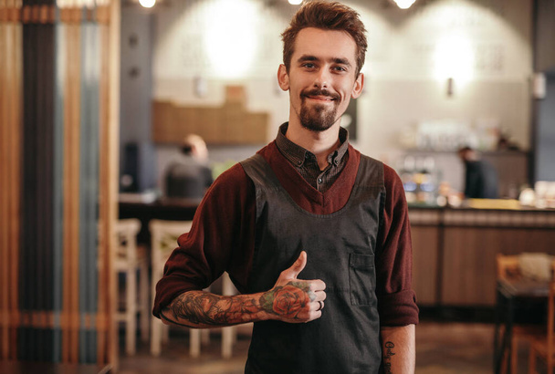 Varón barista aprobar el trabajo en la cafetería - Foto, imagen