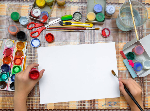 a girl drawing watercolor on a blank white paper, artistic creation at home, makes creative artwork - Photo, Image