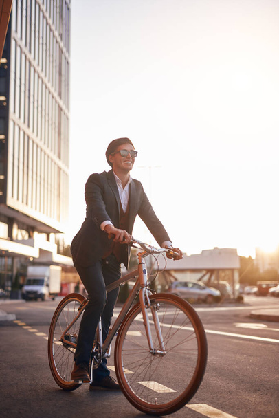 Happy businessman riding bicycle in city - Fotó, kép