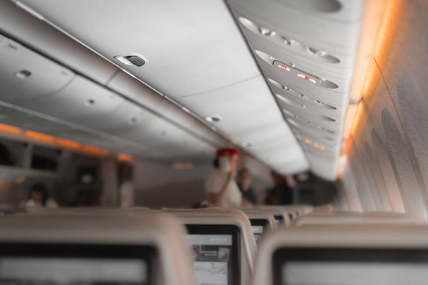 Interior del avión con pasajeros en asientos esperando para despegar. Embalado interior avión comercial. Transporte de viajes y turismo - Foto, imagen