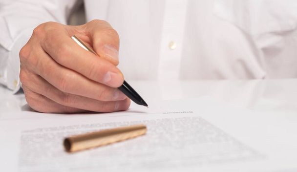 Contract signing concept. Businessman hand with pen over document closeup. - Photo, Image