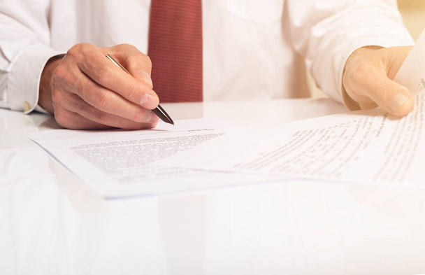 Contract signing concept. Businessman hand with pen over document with copy space available. - Fotoğraf, Görsel